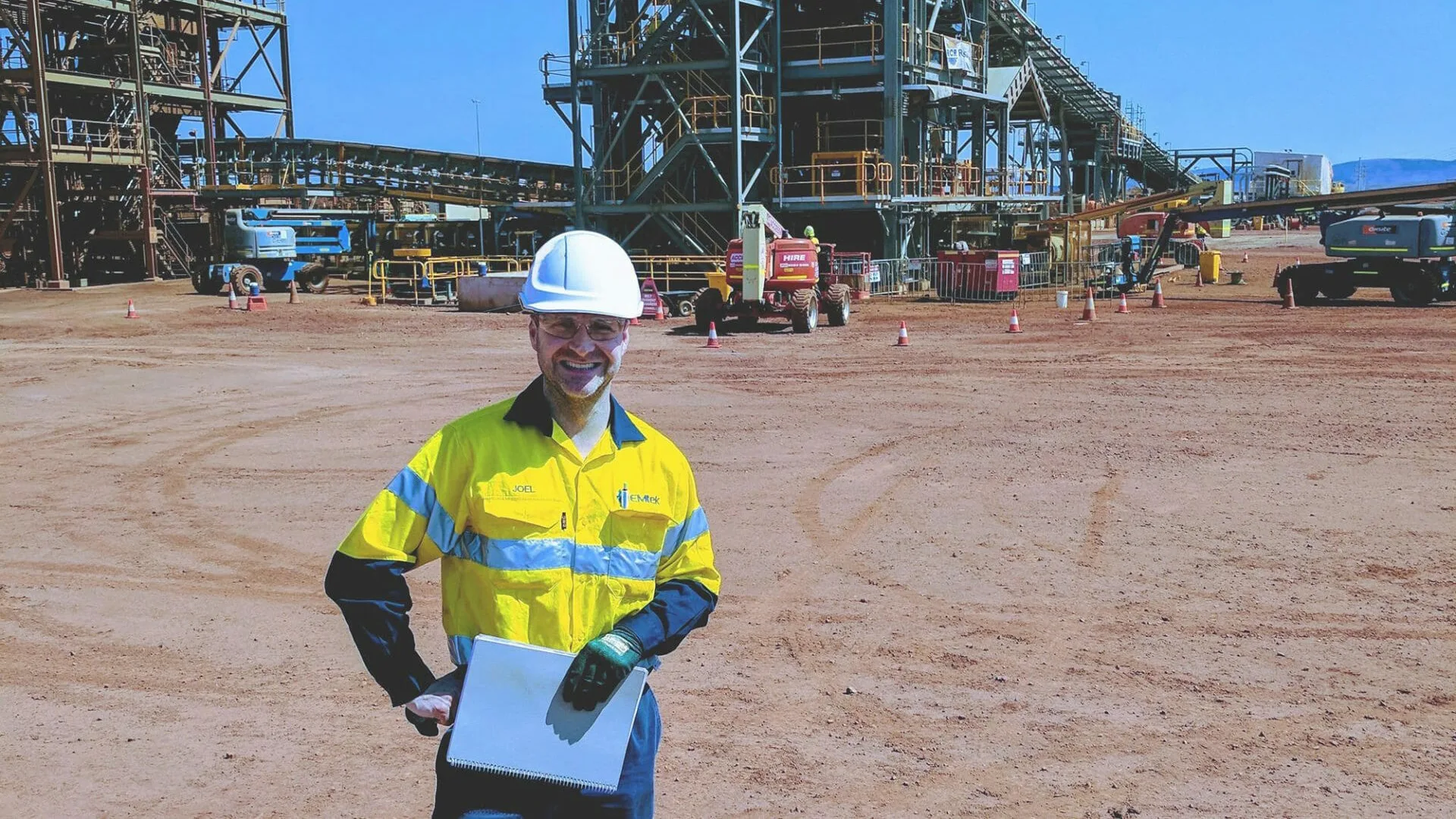 EMtek team member standing in front of a brownfield facility, highlighting the company’s role in delivering safe, large-scale engineering projects.